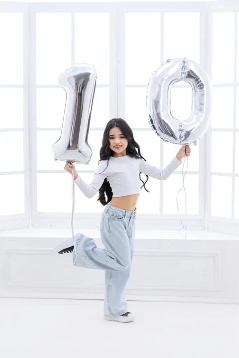 Niña con globos plateados del número diez