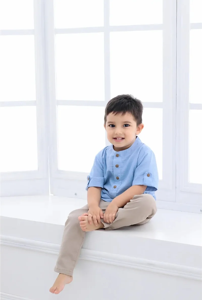 Niño sentado en una ventana blanca